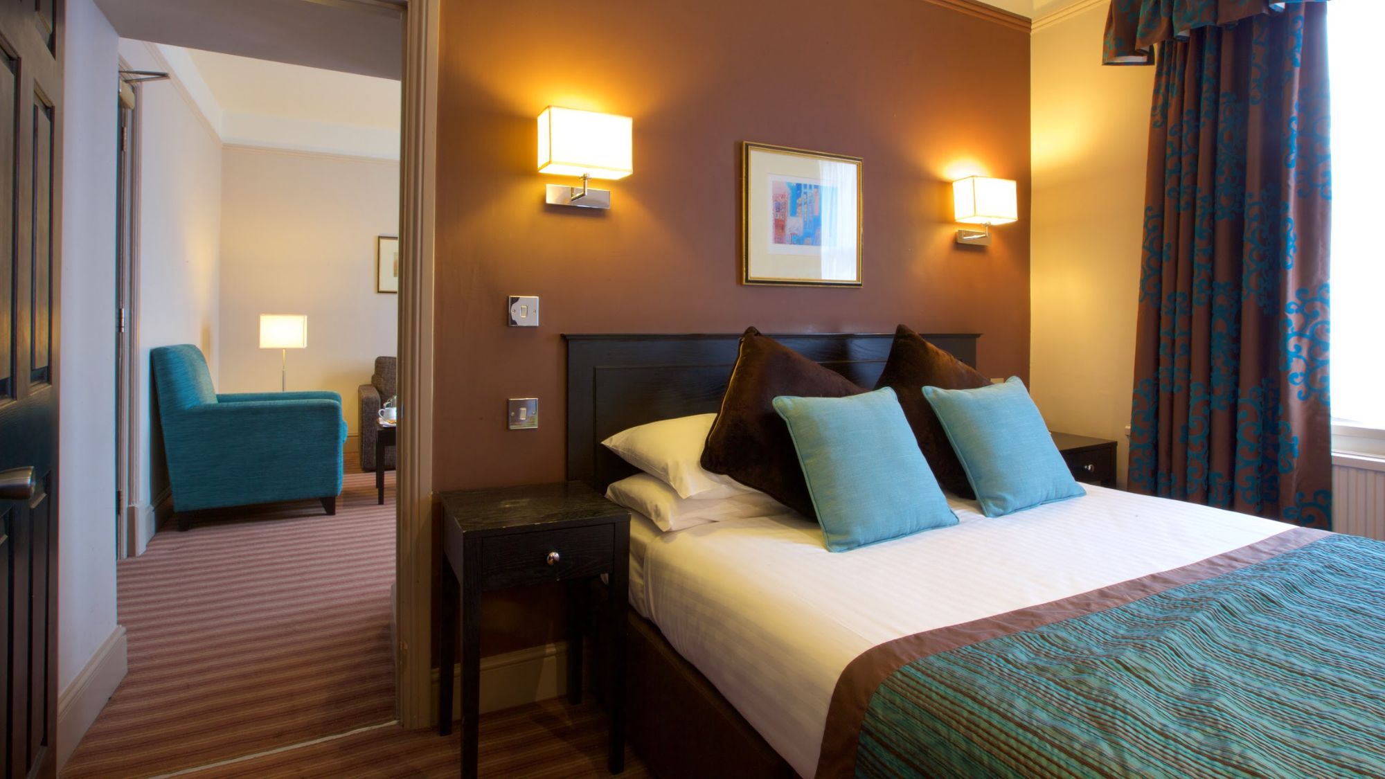 A warm-toned bedroom with twin beds and blue pillows.