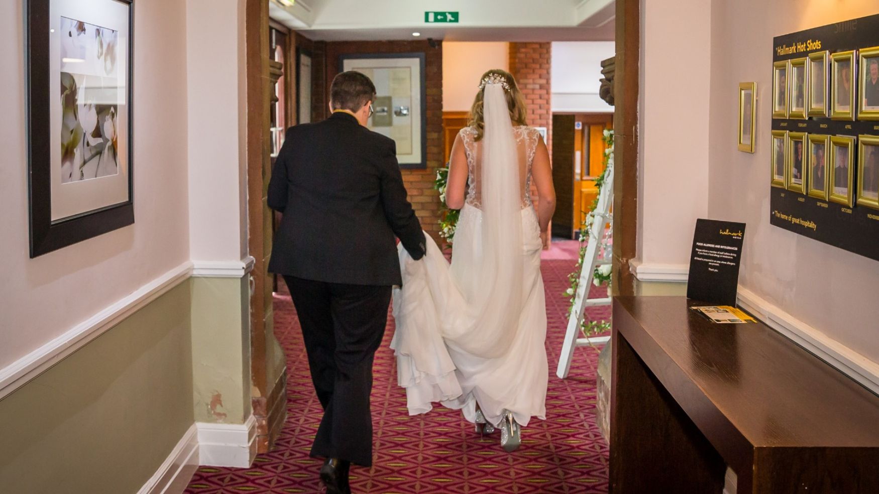 A bride and groom walking hand-in-hand through a doorway.